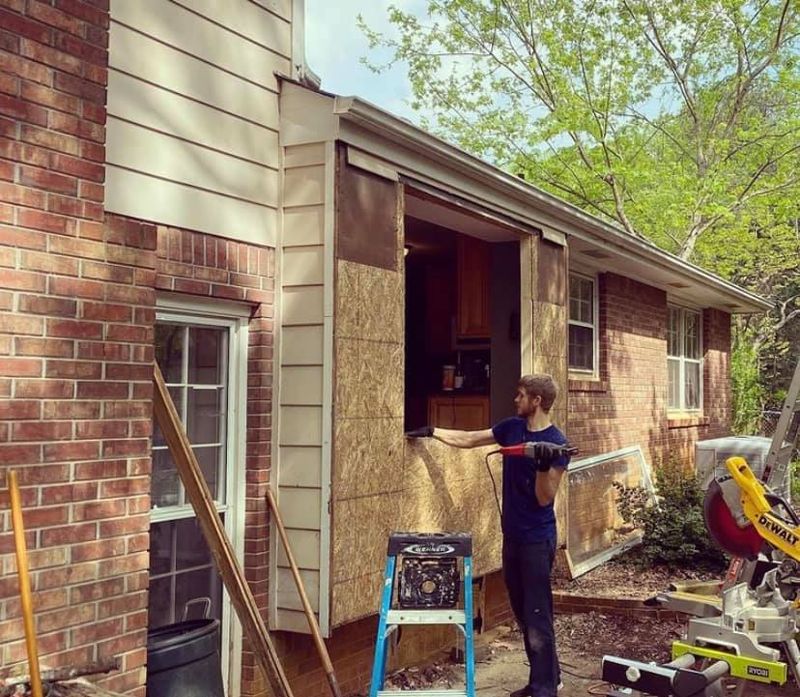Exterior wall opened up with OSB sheathing and framing exposed, old window removed
