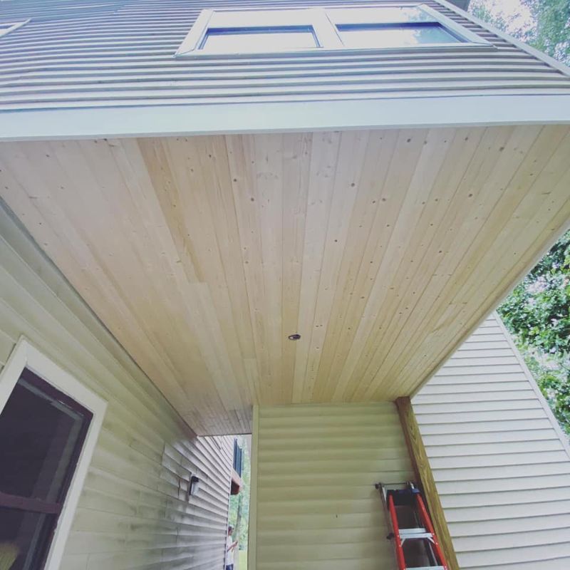 Knotty pine tongue-and-groove ceiling on covered porch looking up toward roofline