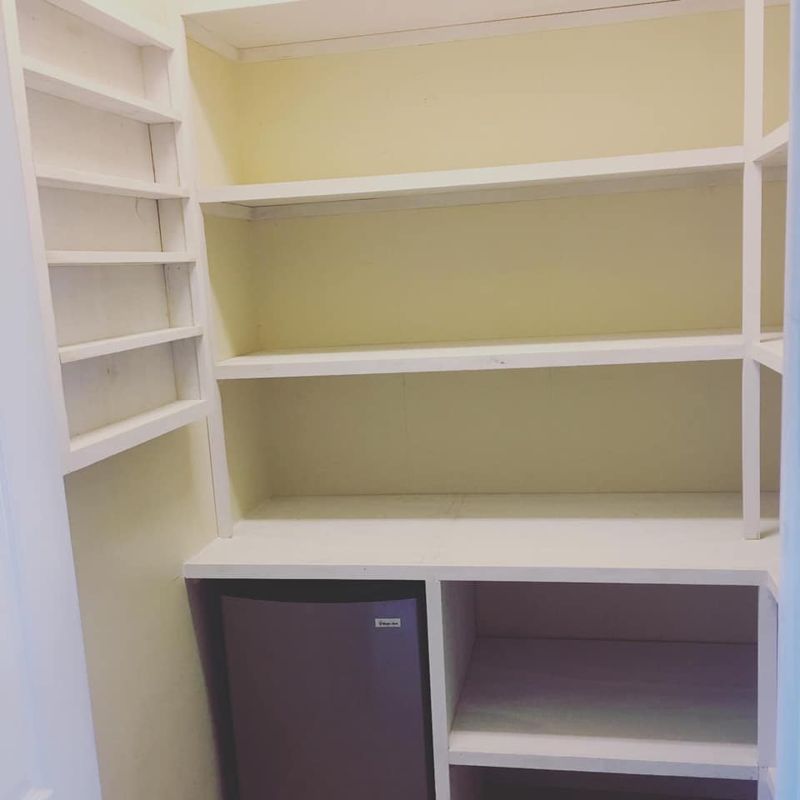 Pantry shelving detail with mini fridge cubby and spice storage sections