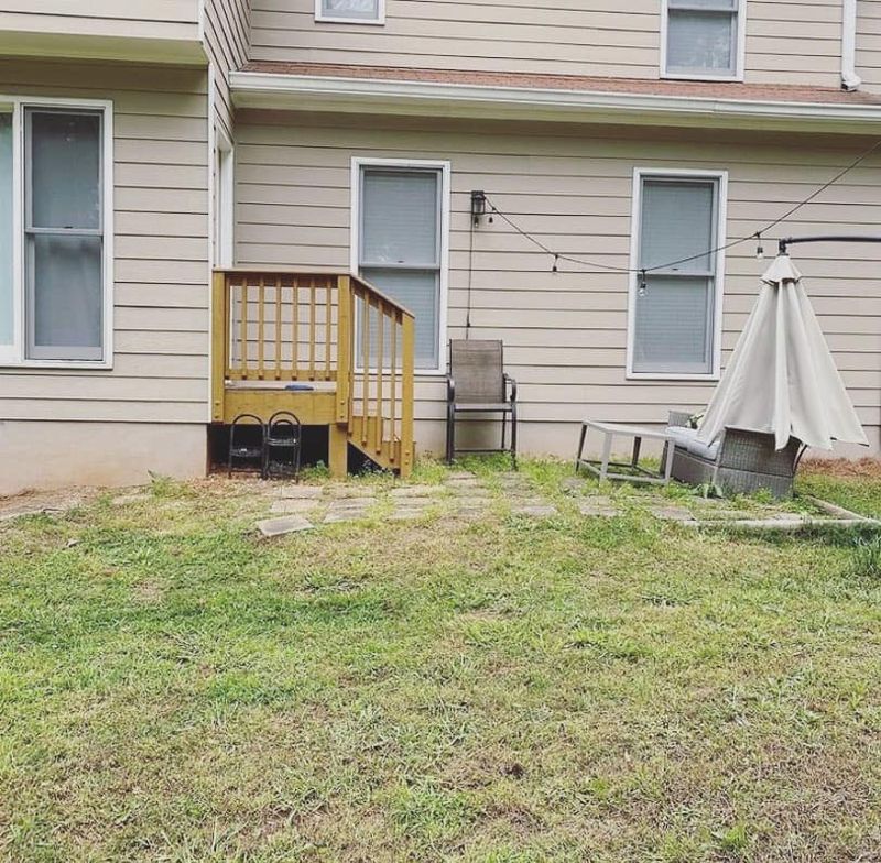 Small back stoop with lattice panel and stepping stones before deck build