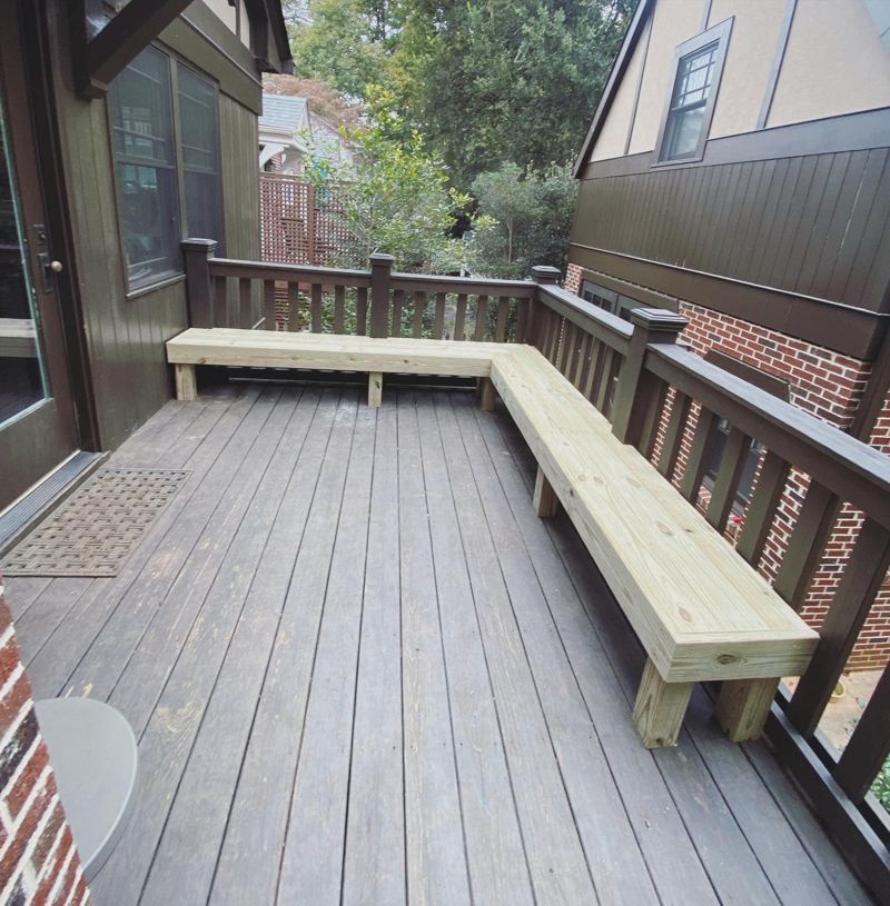 Custom L-shaped pressure-treated bench built into deck railing