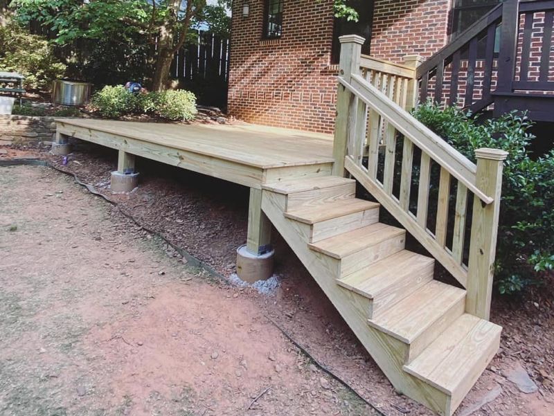 Stair detail with capped newel posts, turned wood balusters, and pressure-treated treads