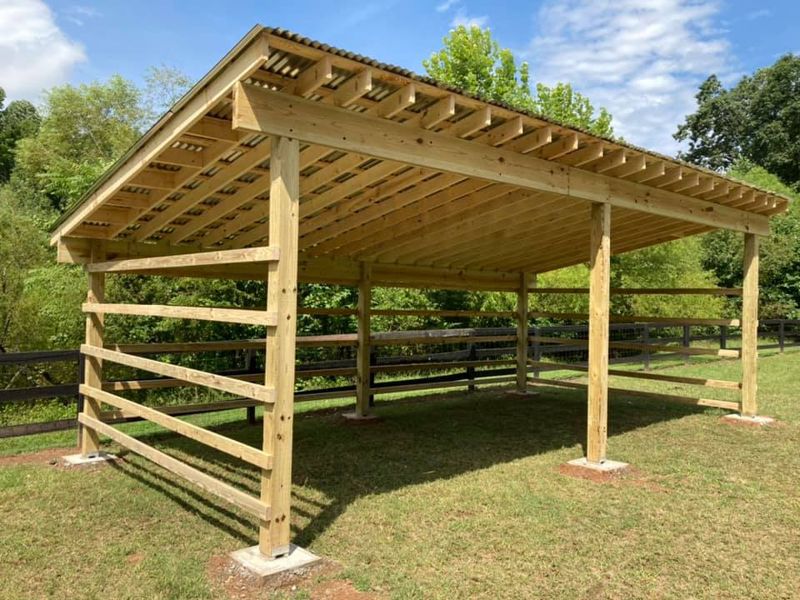Custom post-and-beam run-in shed with pitched roof and horizontal board rails