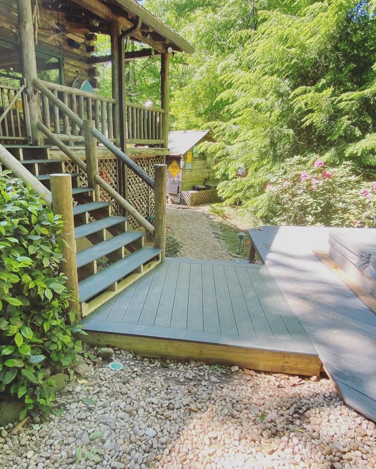 Wide view of composite walkway platform and staircase at log cabin with gravel path