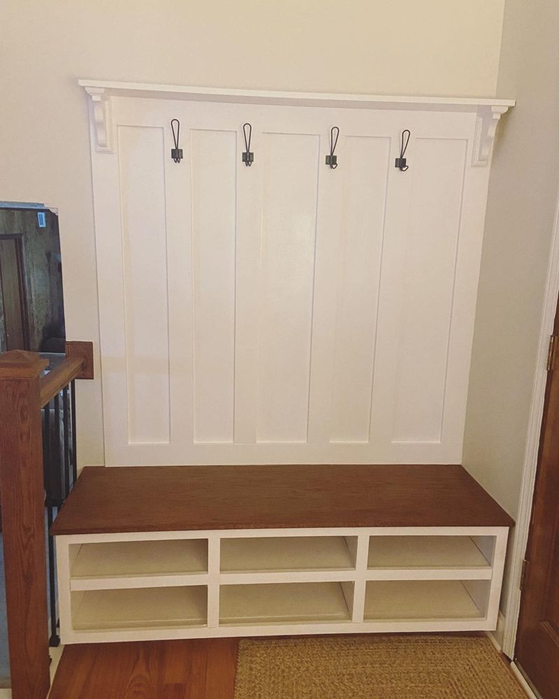 Custom built-in hall tree with board and batten paneling and stained oak bench
