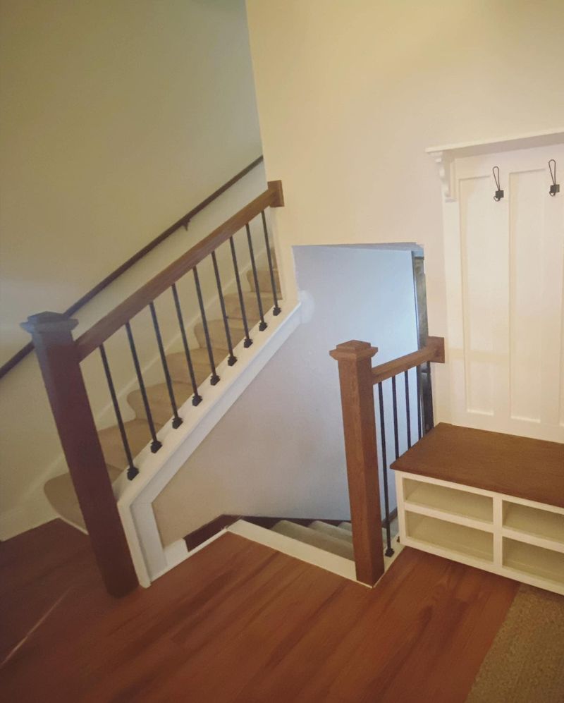 Stained oak handrail with matte black iron balusters on second floor landing