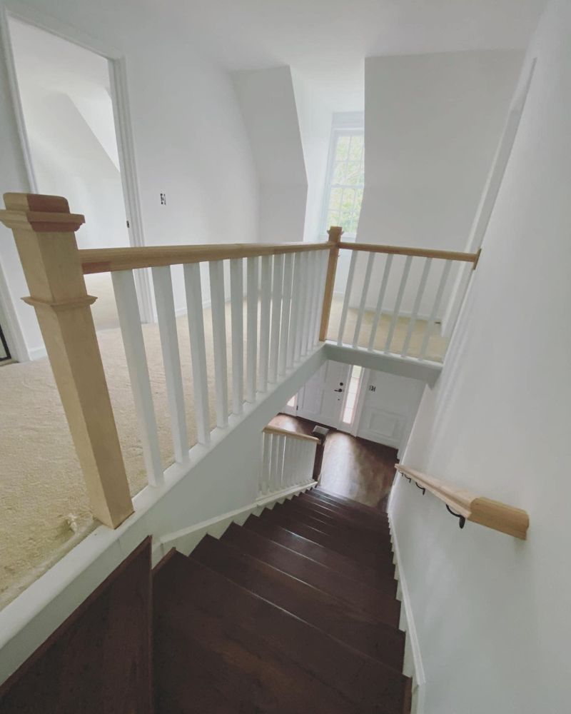 Full staircase view with white oak handrail and dark hardwood treads