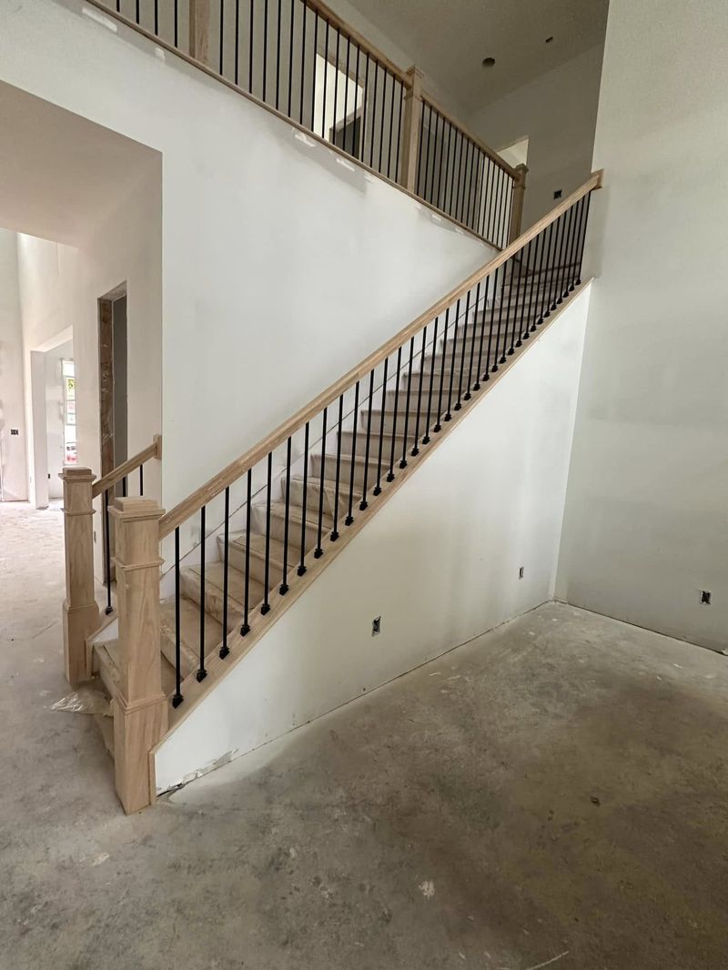 Craftsman newel posts with matte black iron balusters