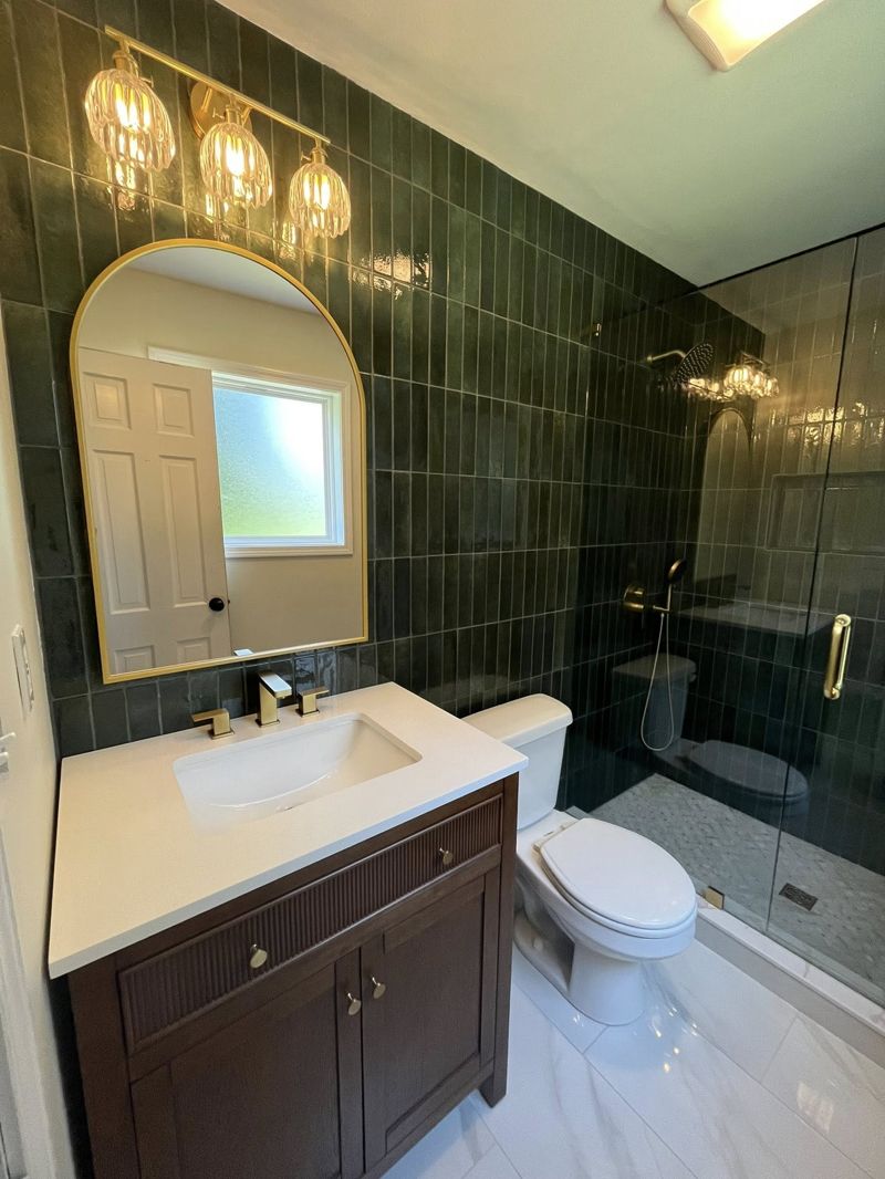 Fluted espresso vanity with white quartz top and arched gold mirror