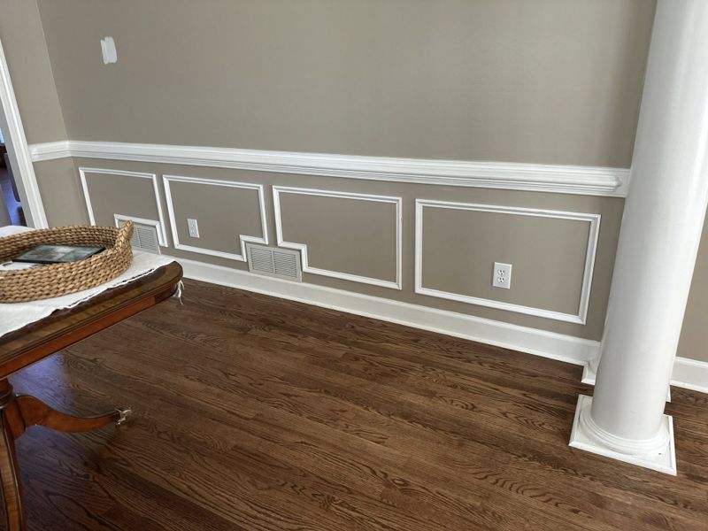 Foyer wainscoting with painted white turned balusters and patterned runner