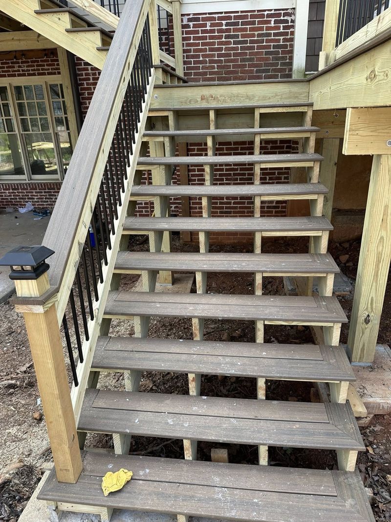 Composite stair treads with rebuilt railing and black iron balusters