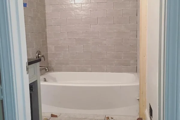 Bathroom remodel: floor-to-ceiling gray subway tile tub surround and new tile floor