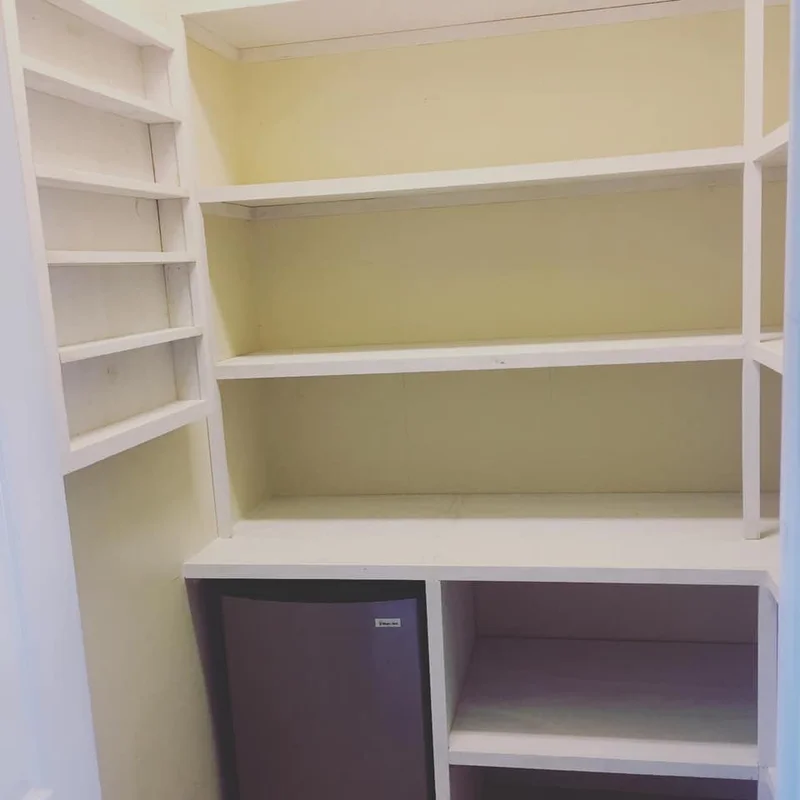 Pantry shelving detail with mini fridge cubby and spice storage sections