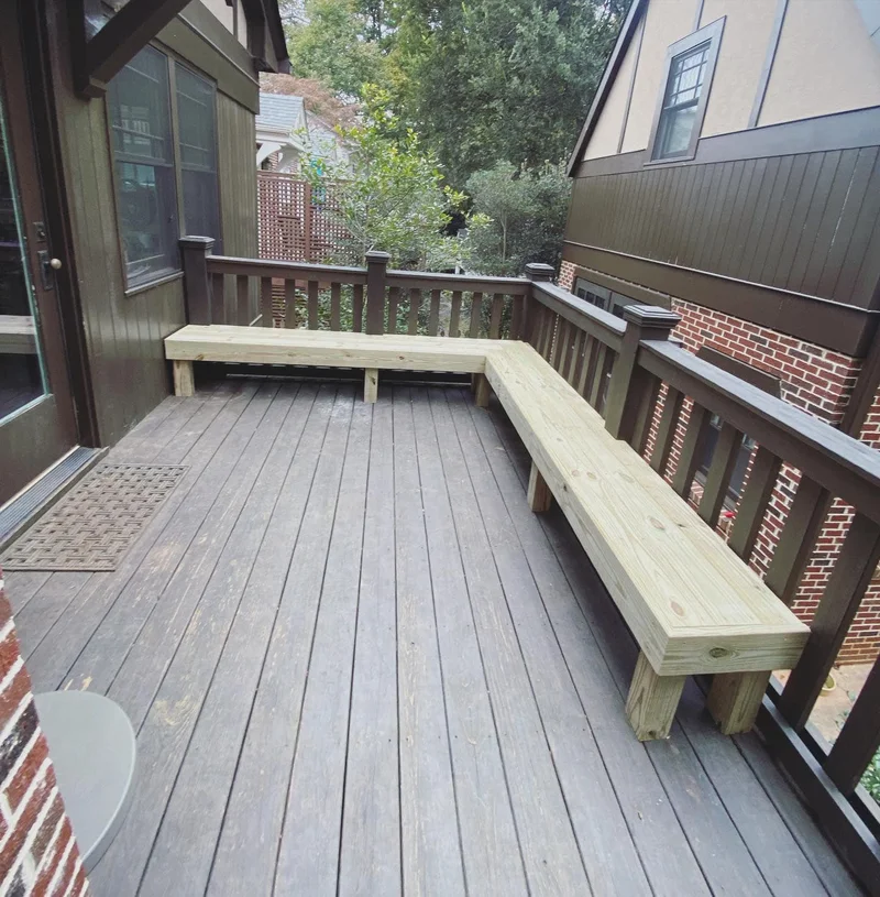 Custom L-shaped pressure-treated bench built into deck railing