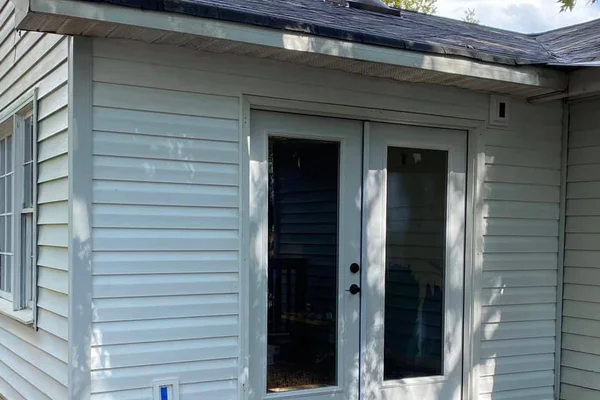 Home exterior with new vinyl siding, French patio door, and exterior electrical outlet