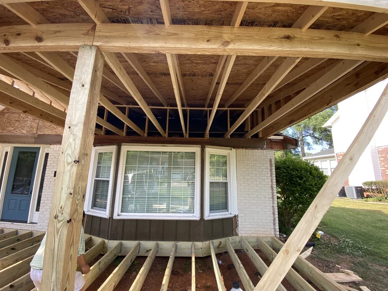 Porch roof joist framing over the bay window during construction