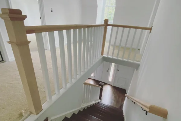 Staircase renovation with white oak handrail and dark hardwood treads