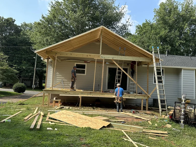 Gable porch roof framing over the new deck with rafters and truss in place