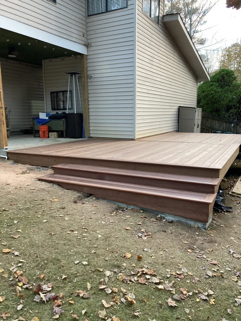 Completed low-profile hardwood deck and steps spanning the back of the house