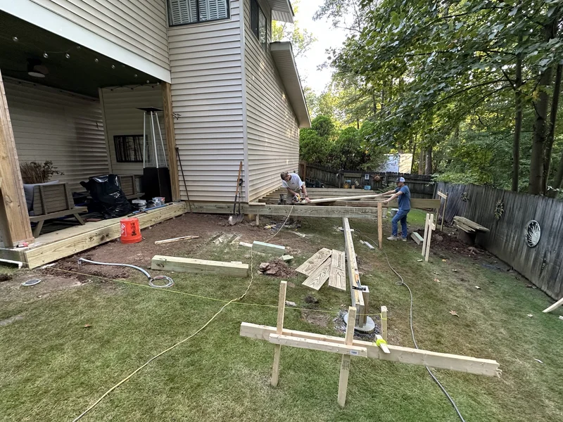 Deck band and beam framing going up on footings against the house