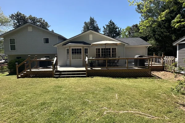 Completed deck spanning the full back of the house with railings, lattice skirting, and outdoor furniture