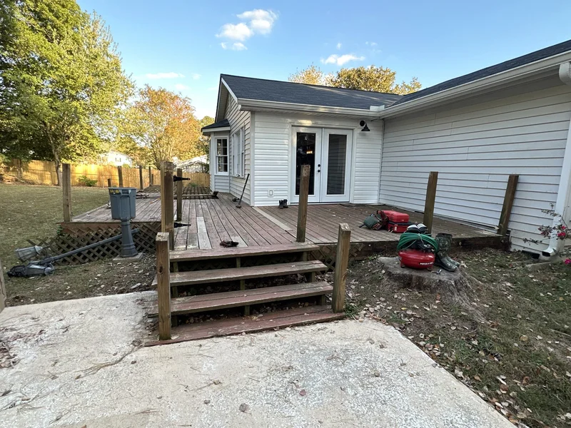 Original weathered deck with aging boards and stairs before tear-out