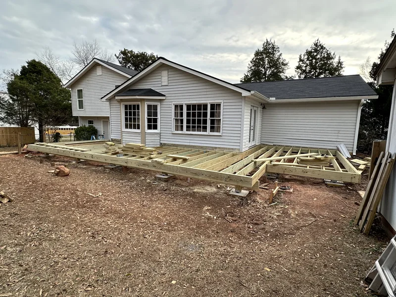 Full deck footprint framed on posts and concrete footings across the back of the house
