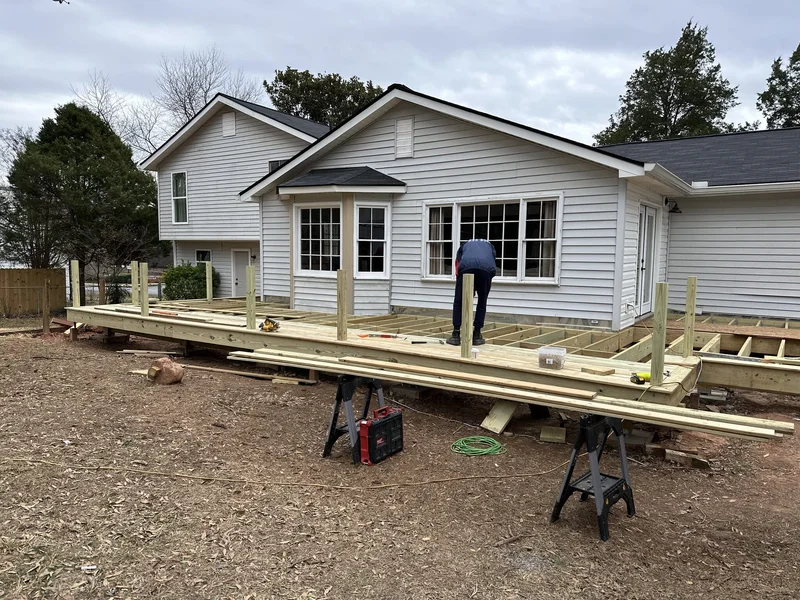 Deck boards being installed over the new pressure-treated framing