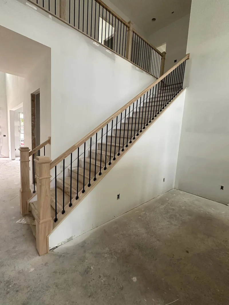 Craftsman newel posts with matte black iron balusters