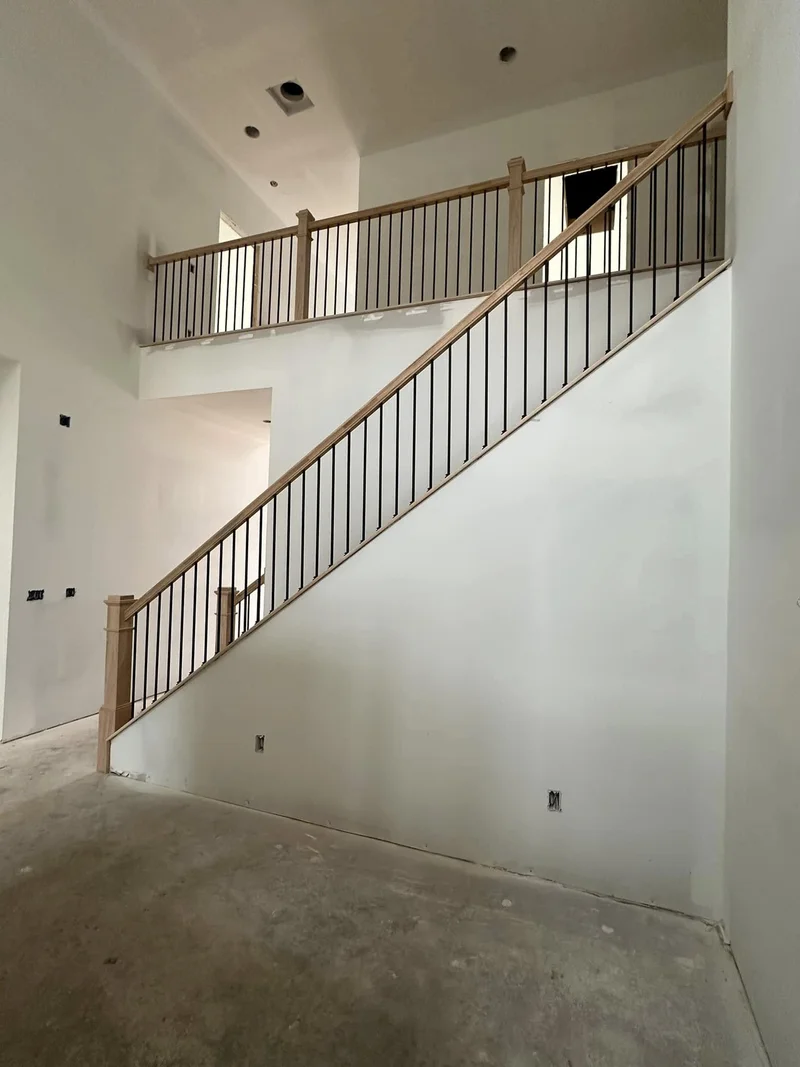 Full stair run from main floor showing seamless railing flow to upper landing