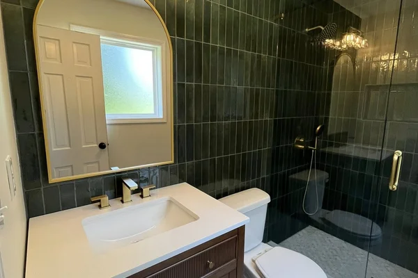 Fluted espresso vanity with white quartz top and arched gold mirror