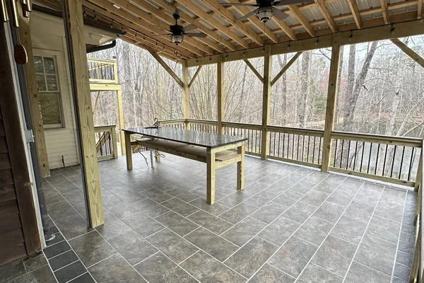 Covered patio construction with heavy timber structure, metal roof, and string lights