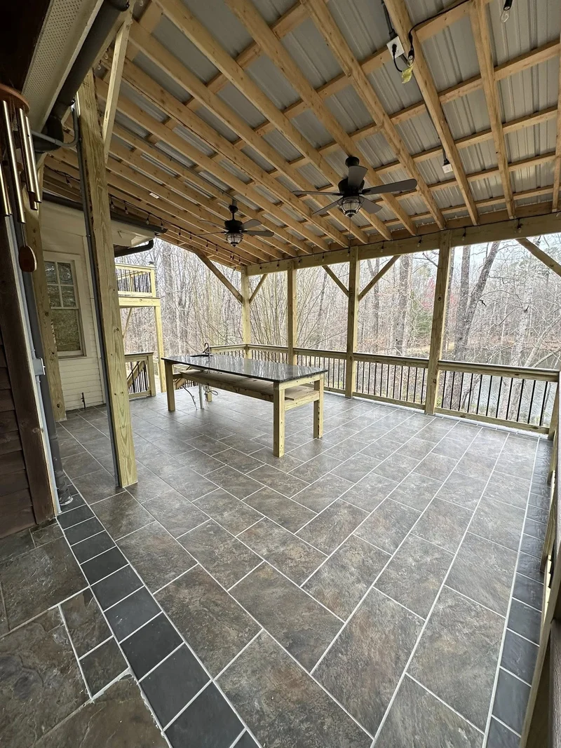 Covered patio construction with heavy timber structure, metal roof, and string lights