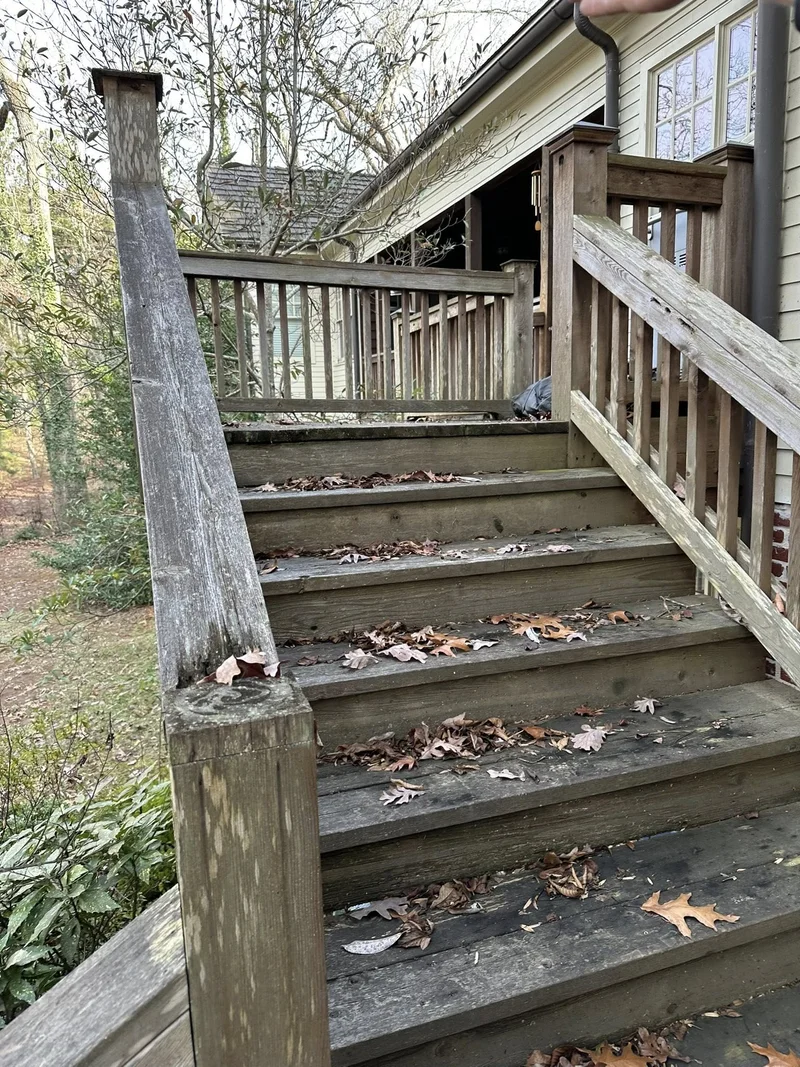Weathered deck stairs with rotting posts before patio renovation