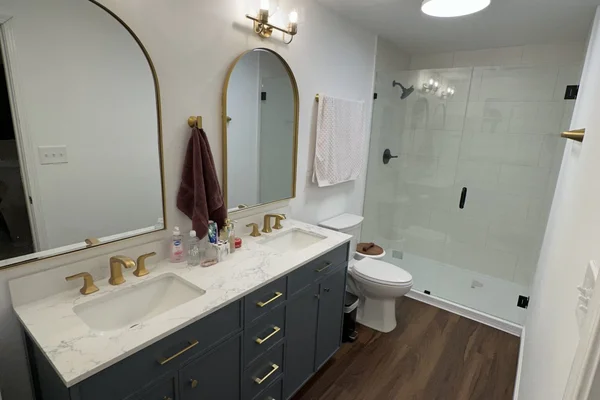 Walk-in shower with large-format white subway tile, built-in niche, and frameless glass enclosure