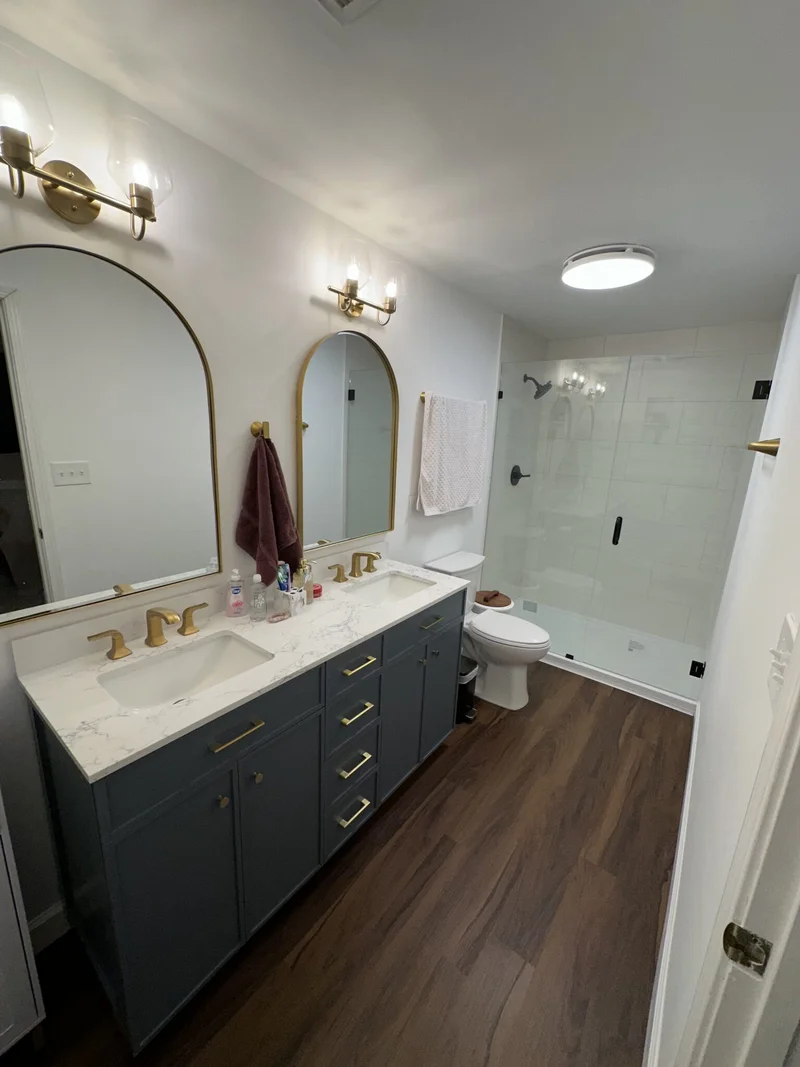 Walk-in shower with large-format white subway tile, built-in niche, and frameless glass enclosure
